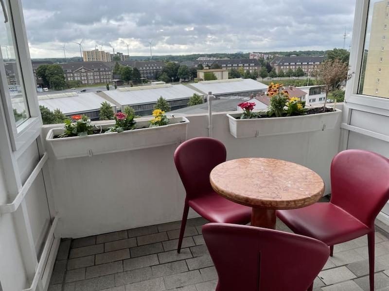 Überdachter Balkon mit Tisch, Stühlen und Blumen in der Ferienwohnung Luna Blu